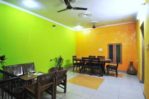 a dining room with green and yellow walls at Satkar Hotel in Jaipur