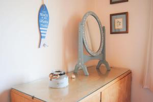 a dresser with a mirror on top of it at Casa dos Pinheiros in Praia da Arrifana