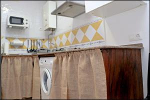 コニル・デ・ラ・フロンテーラにあるApartamento San Lucasのキッチン(洗濯機、乾燥機付)