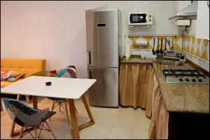 コニル・デ・ラ・フロンテーラにあるApartamento San Lucasのキッチン(冷蔵庫、テーブル、椅子付)