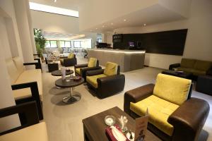 - un salon avec des canapés, des chaises et un bar dans l'établissement Hotel KSAR DHIAFA by PLAZA HOTELS & RESORTS, à Sidi Bouzid