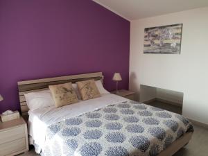 - une chambre dotée d'un lit avec un mur violet dans l'établissement Sea view, à Quartu SantʼElena