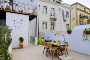 a patio with a table with chairs and an umbrella at Lisbon Lights Apartments in Lisbon