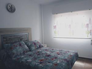 a bedroom with a bed and a clock on the wall at Paseo San Cristóbal in Almuñécar