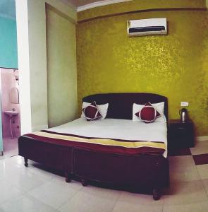 a bed with two pillows on it in a room at Satkar Hotel in Jaipur