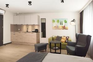 a living room with a couch and a kitchen at Apartamenty Centrum Park in Zielona Góra