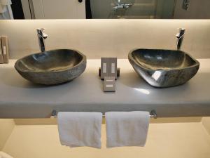 a bathroom with two sinks and towels on a counter at Ilio Maris in Mikonos