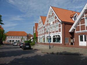 Obsthof Fock في Mittelnkirchen: مجموعة مباني فيها سيارات تقف في شارع