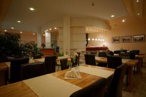 a restaurant with wooden tables and chairs with flowers on them at Noclegi w Lublińcu Lubex in Lubliniec