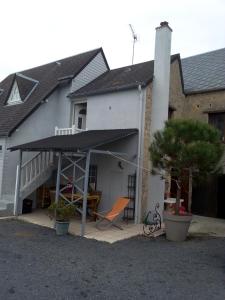 a white house with a patio with a deck at Les Hortensias 26 in Saint-Laurent-sur-Mer