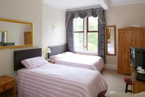 
a bedroom with a bed and a television at Ilkley Riverside Hotel in Ilkley

