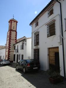 a black car parked in front of a white building at Casa Virués in Grazalema