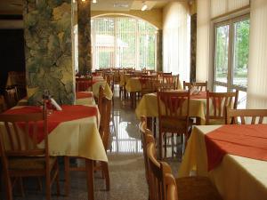 a restaurant with tables and chairs with red and yellow table cloth at Спа Хотел Калифорния in Pavel Banya