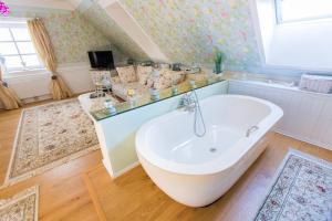 a bathroom with a bath tub in a room at OLEANDER SUITEN großzügig wohnen mit besonderem Charme in Trausdorf