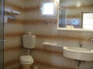 a bathroom with a toilet and a sink and a mirror at Apartments and Rooms Lanča in Rab +42 photos