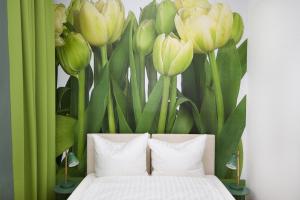 a bedroom with a bed with a painting of flowers at Hotel Reverey * kontaktloser Self Check-In * in Hannover