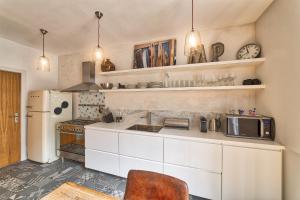 a kitchen with white cabinets and a white refrigerator at Marie Paradis Apartment in Chamonix-Mont-Blanc