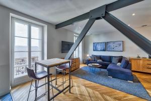 a living room with a blue couch and a table at Marie Paradis Apartment in Chamonix-Mont-Blanc
