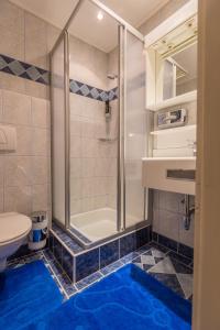 a bathroom with a shower and a blue floor at Party Hotel Taverne in Obertauern