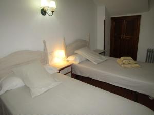 Dos camas en una habitación de hotel con toallas. en Casa Virués, en Grazalema