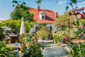 a garden with an umbrella and a house at Oleander Romantik Zimmer in Trausdorf