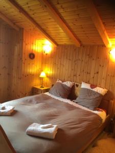 ナンダにあるChalet Pattierの木製の壁の客室の大型ベッド1台