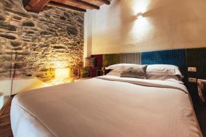 a bedroom with a large bed and a stone wall at Torre di Baratti Bio Resort in Populonia