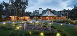 ein großes Haus mit einem Garten mit Lichtern im Hof in der Unterkunft ONOVO Dendra Hotel in Kiew