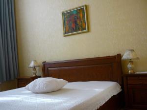 a white bed sitting in a bedroom next to a wall at Hotel Izvora in Arbanasi