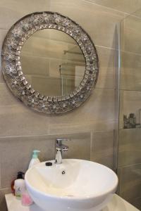 a bathroom with a sink and a mirror on the wall at Central Hotel Guest House in Simonʼs Town