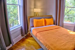 Beautiful Brick 2 Bedroom Home في سافانا: غرفة نوم مع سرير وملاءات برتقالية ونوافذ