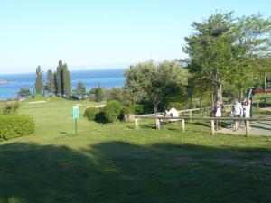 un groupe de personnes assises sur un banc près de l'océan dans l'établissement Cap Esterel place des pecheurs, à Agay 2 autres photos