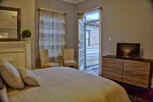 una camera con letto, cassettiera e televisore di Downtown Savannah Oasis a Savannah