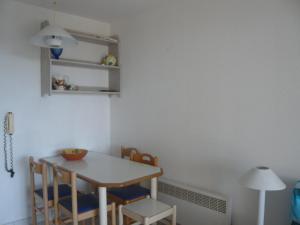 une table et des chaises dans une pièce avec une table et une lampe dans l'établissement Cap Esterel place des pecheurs, à Agay