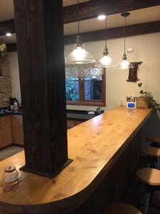 a large wooden counter in a kitchen with pendant lights at DreamWoods in Puerto Varas