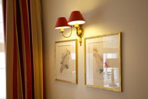two pictures of a bird on a wall with a lamp at Hotel Apia in Vilnius