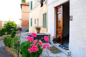 a bunch of pink flowers in front of a door at Siena UpTown - Sabrina's Cozy Apartment in Siena