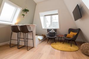 een kleine woonkamer met stoelen en een tafel bij Saint Claire Studio's in Amsterdam
