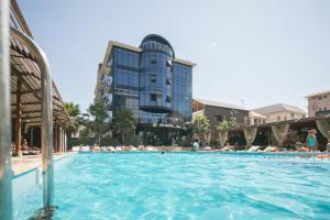 a pool at a resort with people in the water at Экодом Адлер, hotels&SPA in Adler