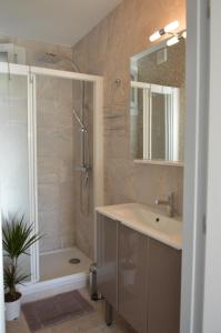 a bathroom with a shower and a sink and a tub at Coste Location Cassis in Cassis