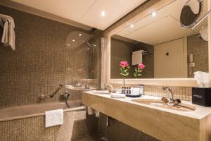 
a bathroom with a sink, mirror, and bath tub at Royal Plaza Montreux in Montreux
