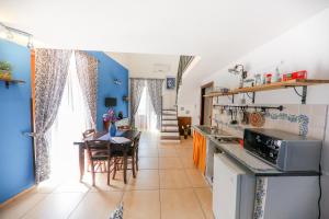 a kitchen and dining room with blue walls and a table at Madonie Holidays in Cefalù