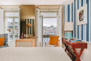 a bedroom with a bed and a desk and a room with a view at Gran Cruz House in Porto