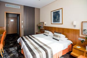um quarto de hotel com uma cama grande num quarto em Hotel Lycium Debrecen em Debrecen
