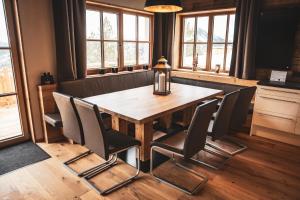 a table and chairs in a room with windows at Wildererhütte Chalet Helmut in Turracher Hohe