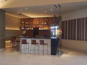 a kitchen with a bar with stools and a counter at Flat Olímpia Park Resort in Olímpia