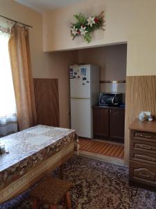 a kitchen with a white refrigerator and a table at Na Gorbochku in Podobovets