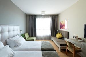 una camera d'albergo con letto e divano di Shefayim Kibbutz Hotel a Shefayim
