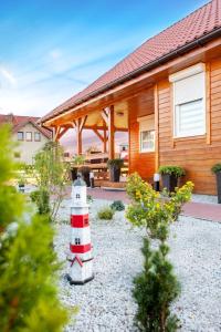 a house with a red and white lighthouse in front of it at DomekTomek z kominkiem i ogrodem 1000m in Niechorze