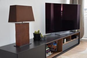 a living room with a flat screen tv on a entertainment center at Paddy's Place in Lille